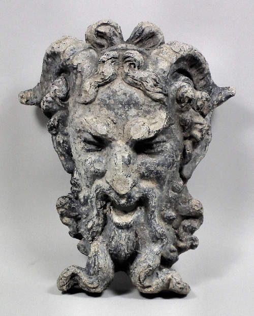 A cast lead mask of a satyr with gaping