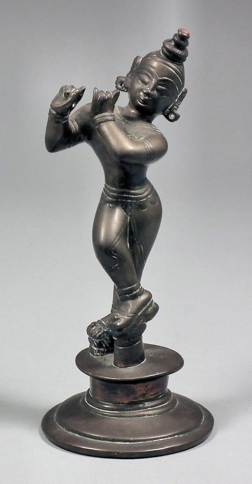 An Indian bronze standing figure playing