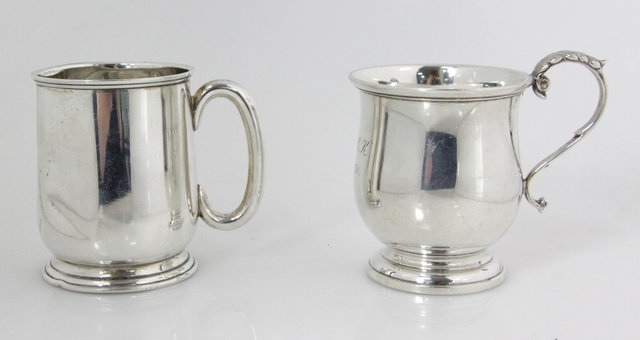 A silver christening mug with scroll
