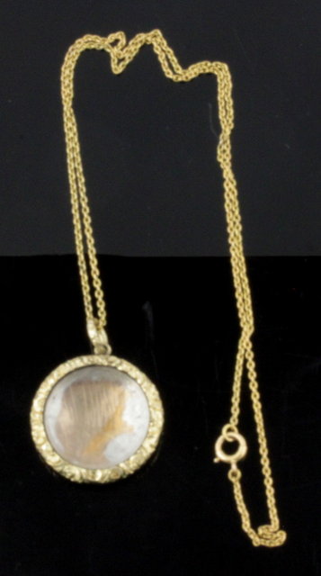A circular gold pendant with engraved