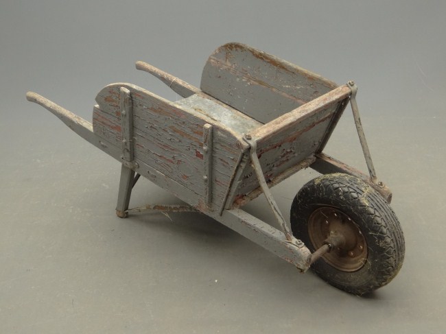 Primitive wheelbarrow in grey paint.