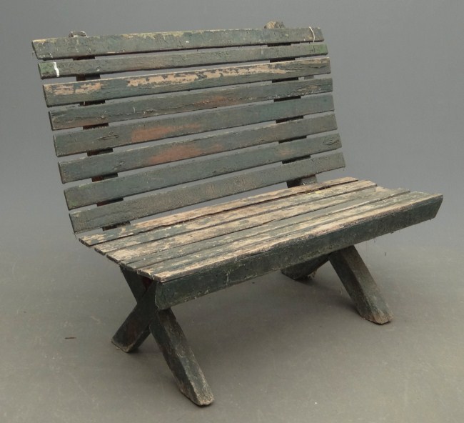 Primitive slat bench in green paint.