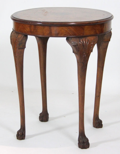 A circular walnut table on cabriole