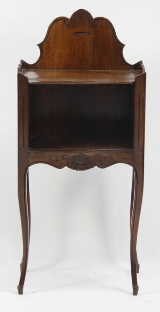 A bedside table with carved back and