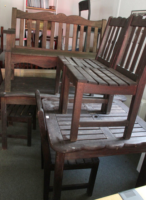 A suite of teak garden furniture comprising