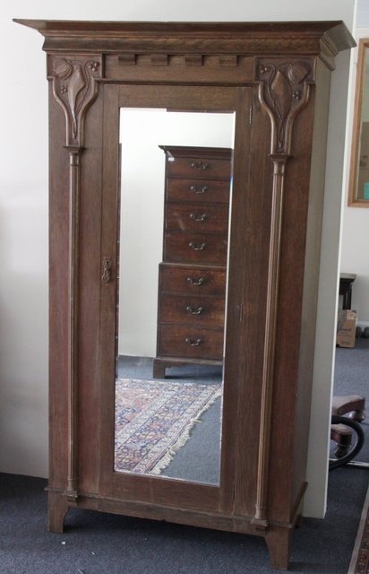 An Art Nouveau wardrobe carved foliate