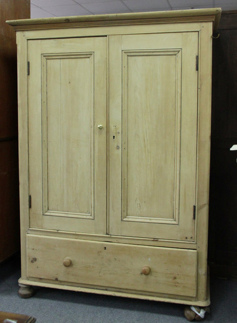 A pine wardrobe enclosed by a pair of