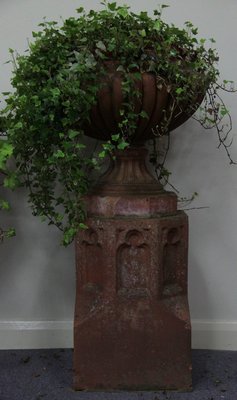 A terracotta lobbed urn on a Gothic 165ace