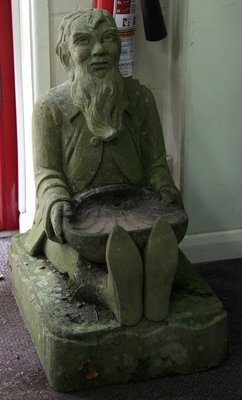 A stone carving of a seated gnome