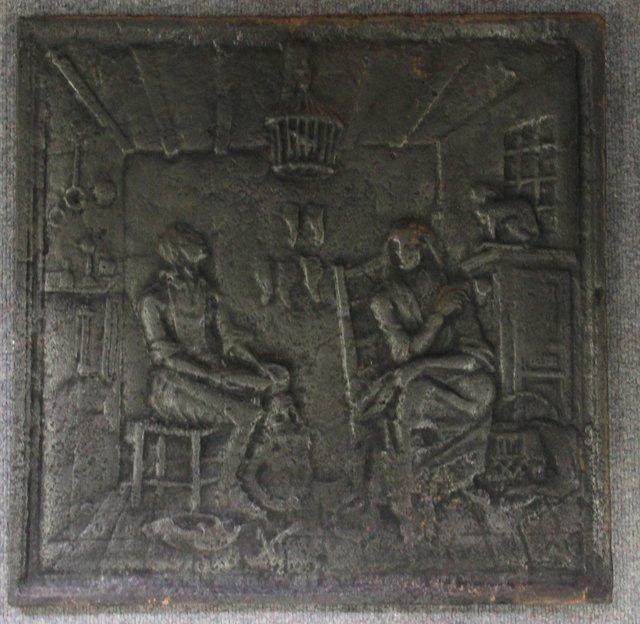 A cast iron fire back decorated in low