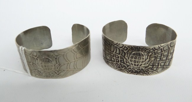 Pair spider decorated cuff bracelets.