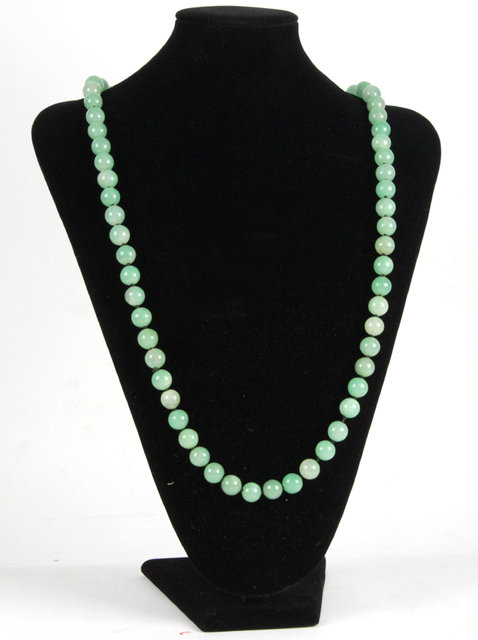 A jade bead necklace of pale green colour