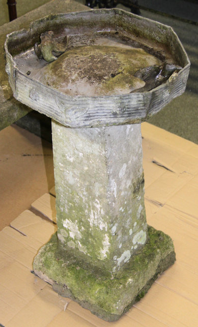 A lead bird bath on a stone column