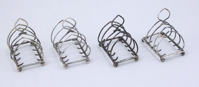Four silver toast racks S.S. and