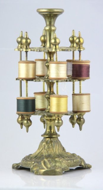 A cast brass cotton reel holder