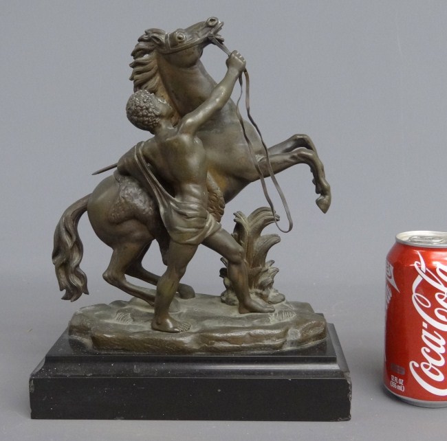 Bronze horse and handler on marble base.
