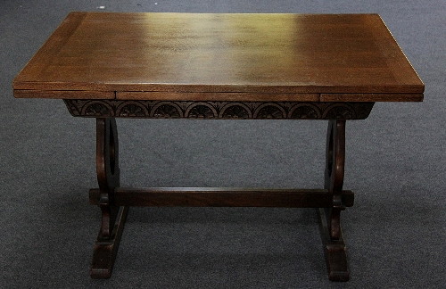 An oak draw-leaf dining table on