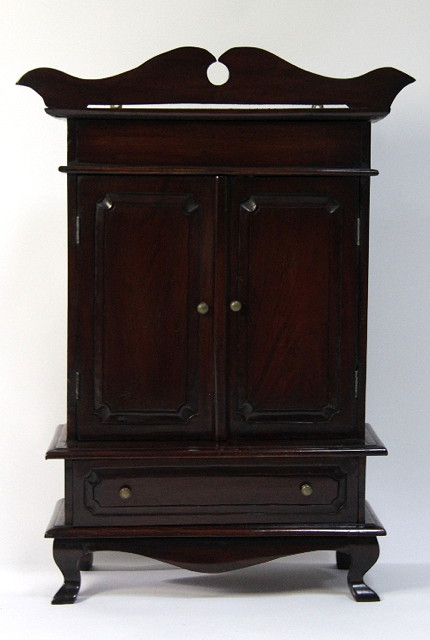 A miniature cabinet with shaped cornice