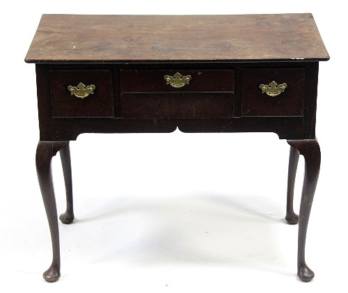 A mahogany three-drawer side table on