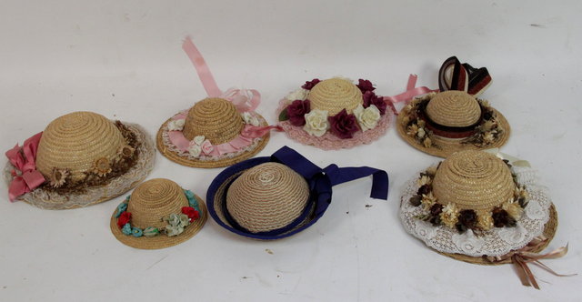 A collection of eight dolls straw hats