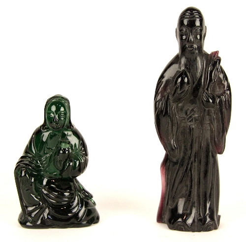 A green glass figure seated with
