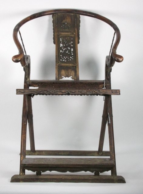 A Chinese folding armchair with carved