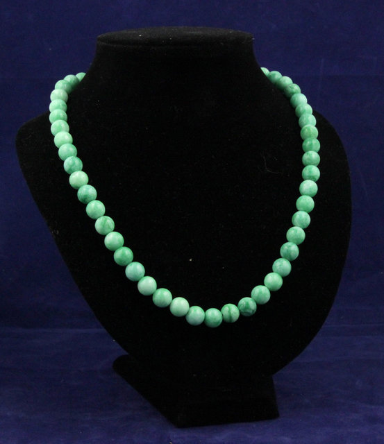 A jade bead necklace 56cm (22) long