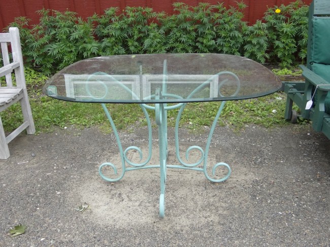 Glass top tubular base patio table.