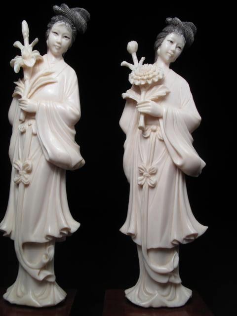 Pair of carved ivory figurines. Each