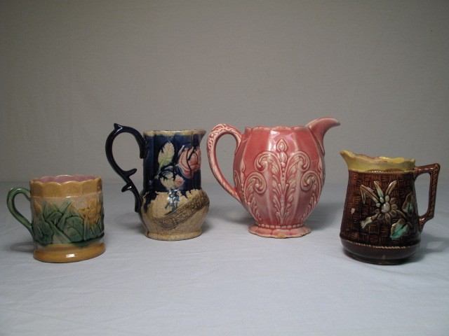 Lot of four Majolica pottery pitchers.