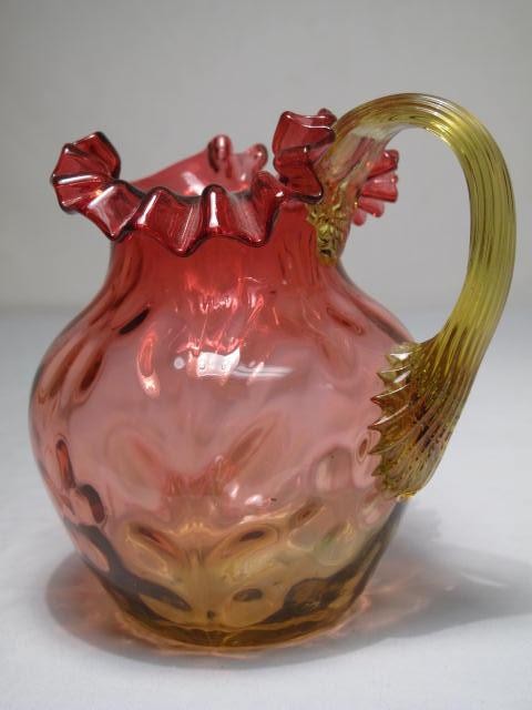 An Amberina glass pitcher with ruffled