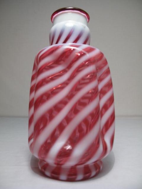 A cranberry glass vase with white