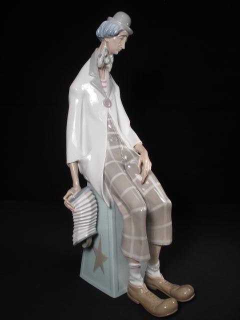 A Lladro porcelain clown holding a Concertina.