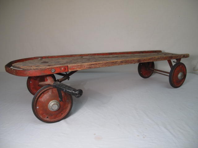Vintage wooden sled with wheels.