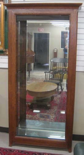 AN OAK AND BEVELED GLASS CURIO CABINET