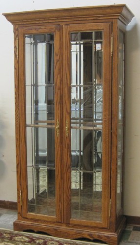 AN OAK LEADED AND BEVELED GLASS CURIO