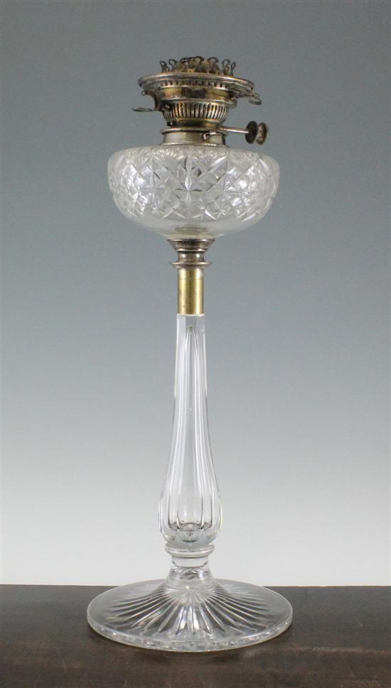 A Victorian cut glass oil lamp on a