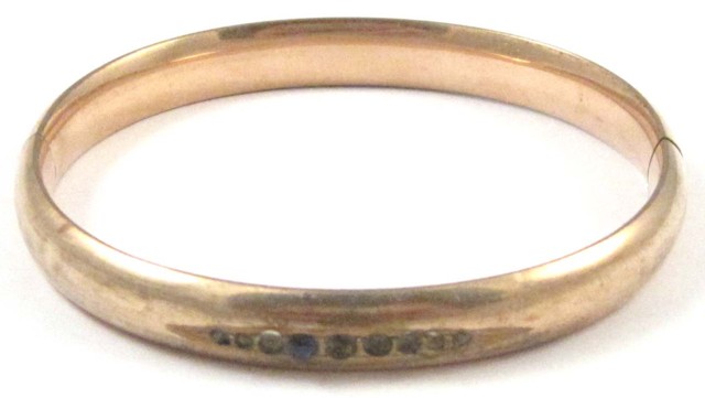 TEN KARAT GOLD HINGED BANGLE. The