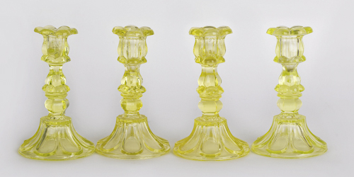 Four sandwich vaseline glass candlesticks