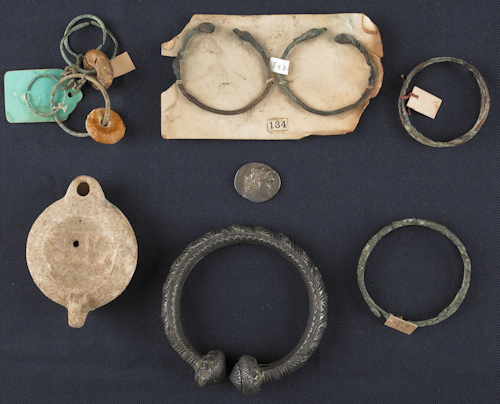 Group of Greek jewelry and pottery vessels.