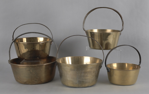 Five brass pots with fixed iron handles.