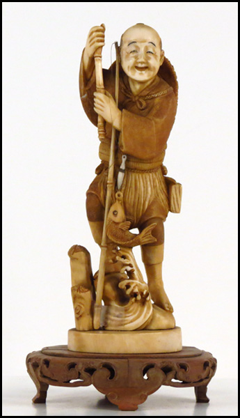 JAPANESE CARVED IVORY FIGURE OF A FISHERMAN.