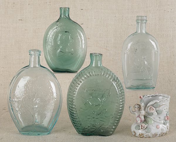 Four glass flasks together with a porcelain