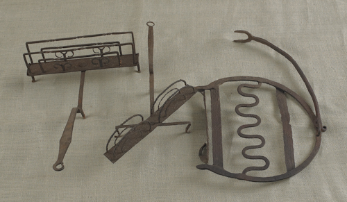 Two wrought iron toast racks together