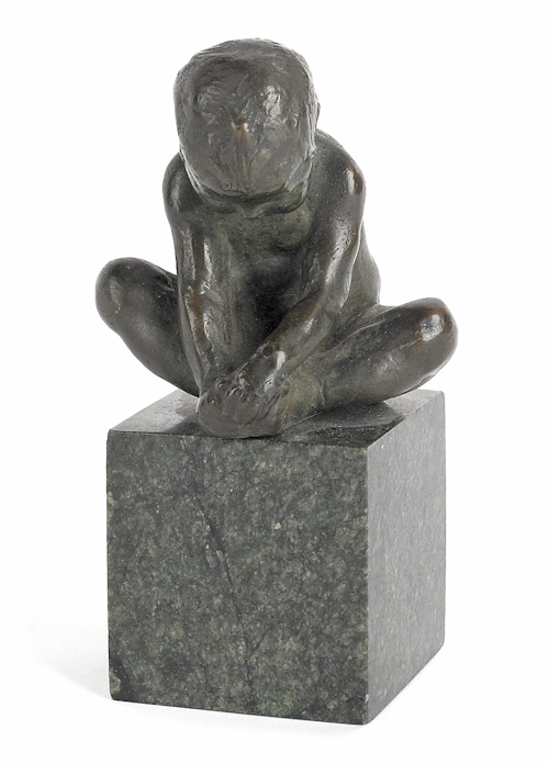 Small bronze of a seated boy on