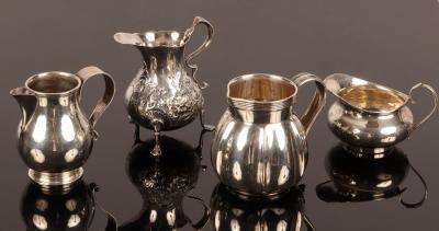 Four silver jugs, including one