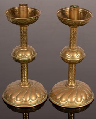 A pair of copper and brass candlesticks