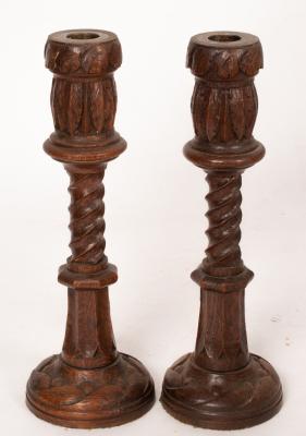 A pair of turned oak candlesticks with