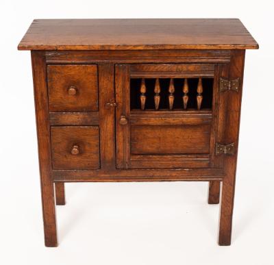 An oak cupboard enclosed by a spindle