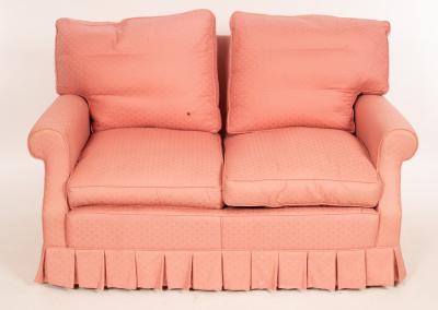 A two-seater sofa upholstered in pink,
